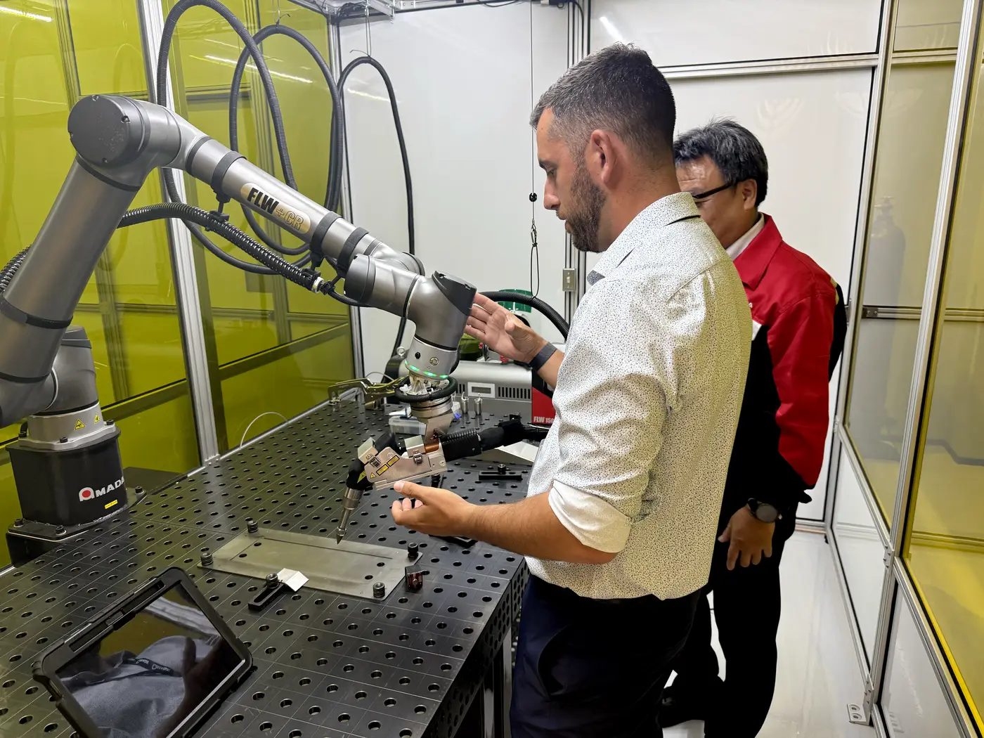 Ingénieur d'application d'AMADA faisant la démonstration de la cellule de soudage robotisée collaborative